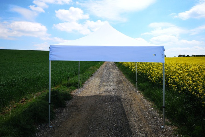 Nožnicový promo stánok 3x6m biely na ceste medzi poľami